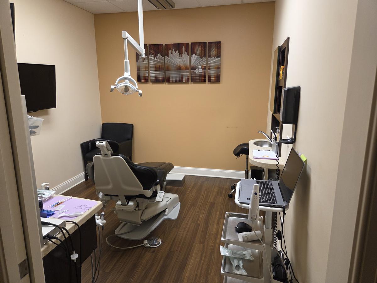 Private treatment room with dental chair, overhead light and chairside monitor at Comfort Family Dental